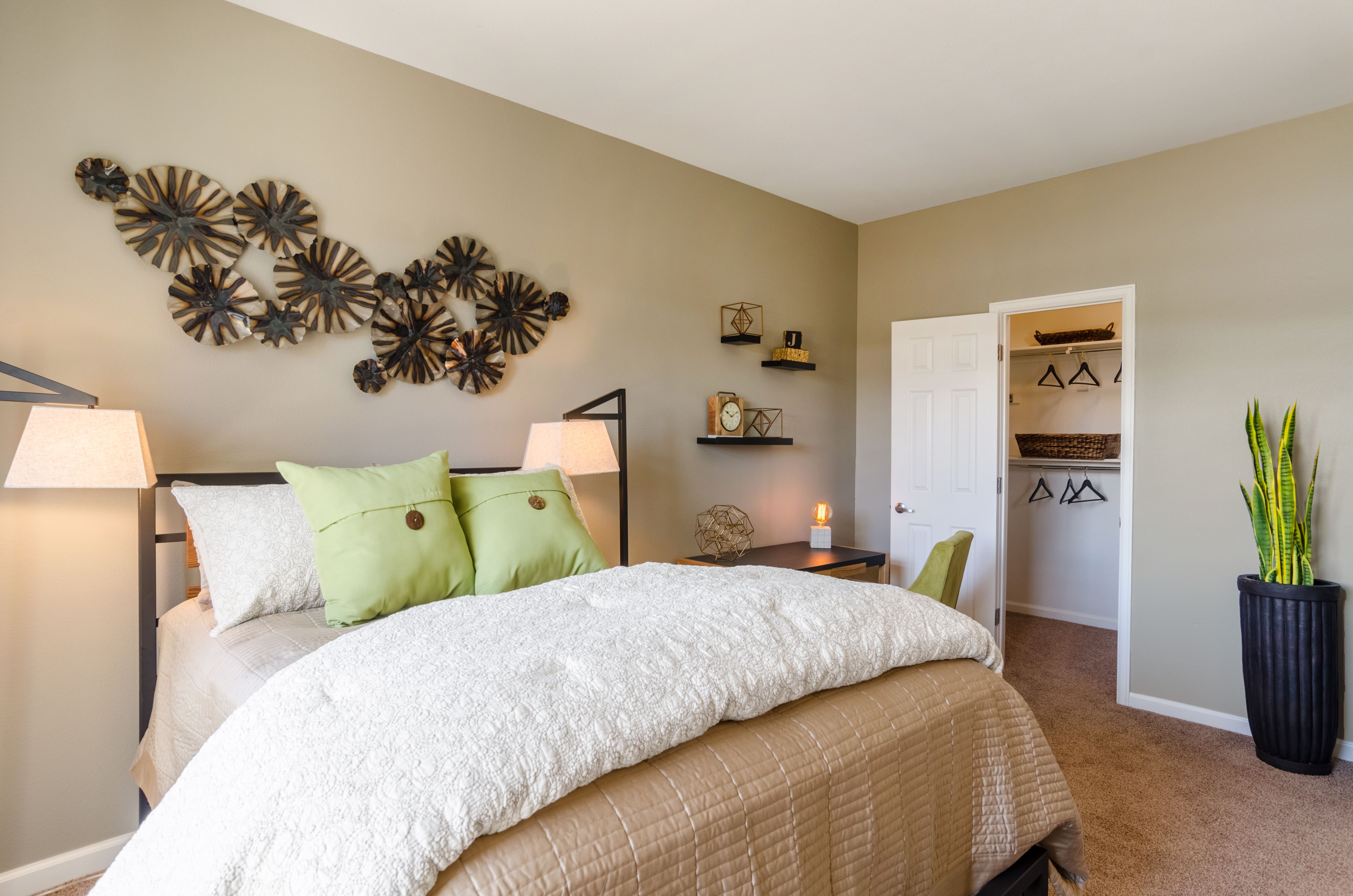 A bedroom with a large bed and a wall decoration.